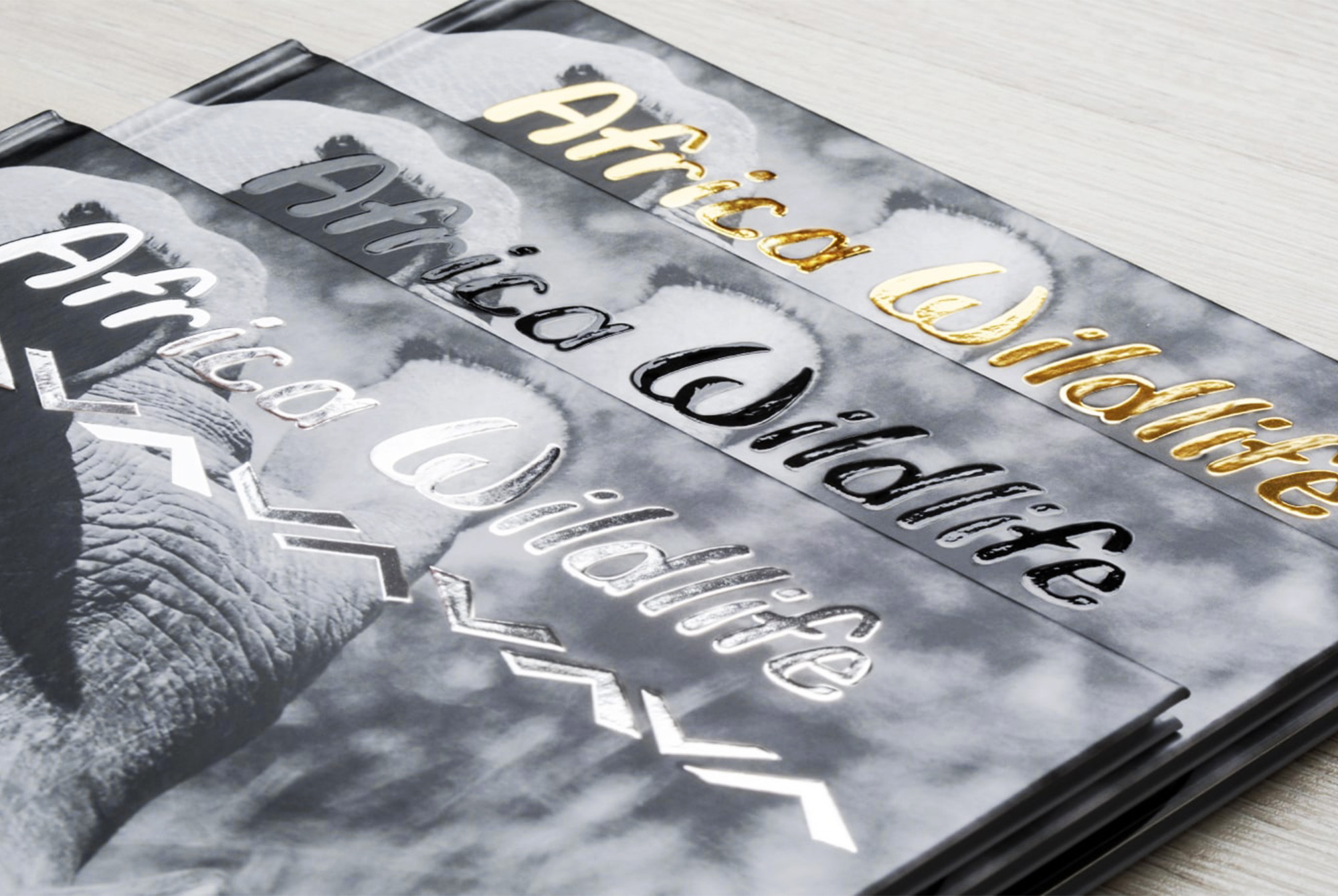 Czarno-białe okładki fotoksiążek z napisem „Africa Wildlife” ozdobionym złotym, srebrnym i czarnym tłoczeniem Czarno-białe okładki fotoksiążek z napisem „Africa Wildlife” ozdobionym złotym, srebrnym i czarnym tłoczeniem